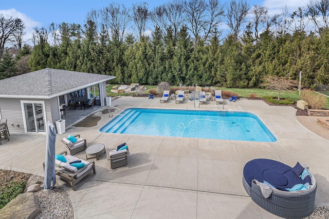 pool with a patio area, a storage structure, and an outdoor structure