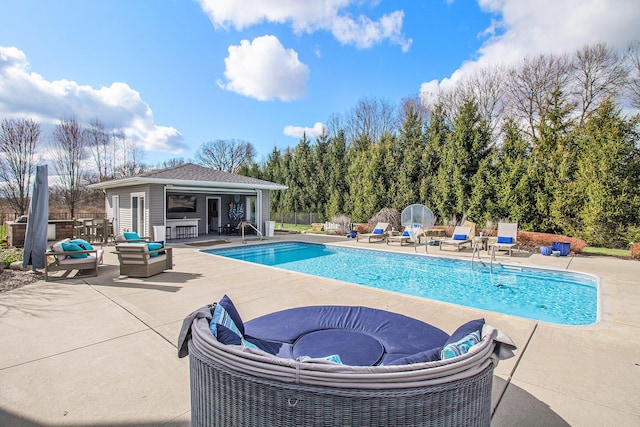 view of pool featuring an exterior structure, an outdoor structure, a patio area, fence, and a fenced in pool