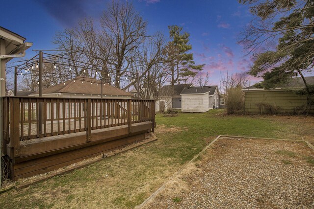 249 Wentworth Ave, Battle Creek, MI 49015 - yard at dusk featuring a shed, a wooden deck, and an outdoor structure
