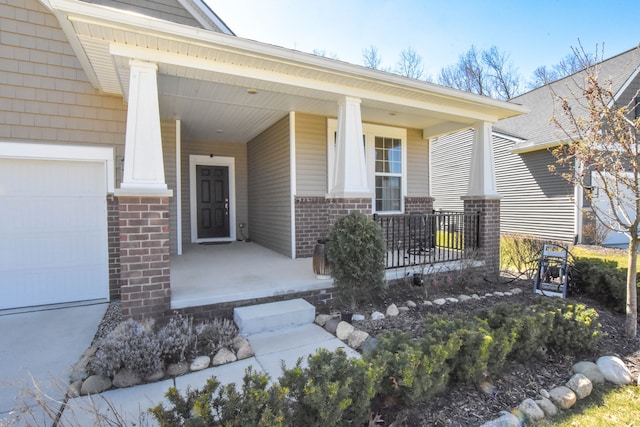 doorway to property featuring a porch, a garage, and brick siding