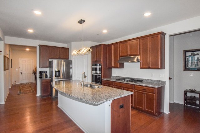 kitchen featuring under cabinet range hood, stainless steel appliances, dark wood-style flooring, and a sink