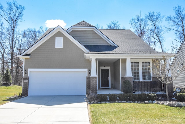 craftsman inspired home with covered porch, an attached garage, a front yard, brick siding, and driveway