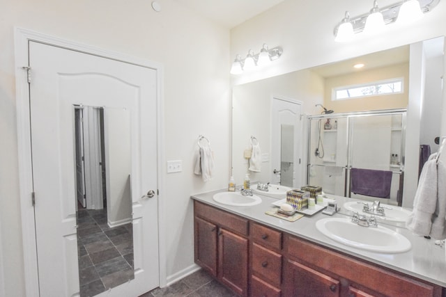 bathroom with a stall shower, tile patterned flooring, double vanity, and a sink