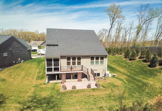 rear view of property with a patio, a sunroom, a deck, a yard, and roof with shingles