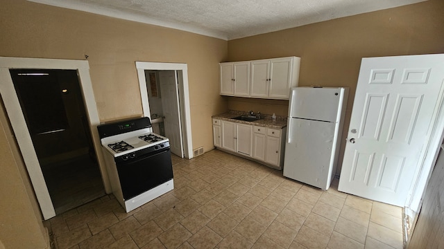 4107 N Campbell St, Detroit, MI 48210 - kitchen with white cabinets, a sink, freestanding refrigerator, and range with gas cooktop
