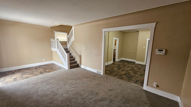 4107 N Campbell St, Detroit, MI 48210 - unfurnished living room featuring dark colored carpet, stone finish floor, baseboards, and stairs
