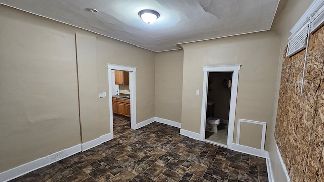 4107 N Campbell St, Detroit, MI 48210 - unfurnished bedroom featuring stone finish floor, ensuite bath, and baseboards