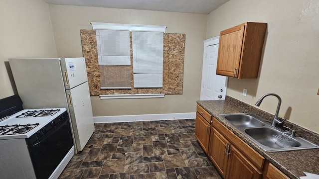 4107 N Campbell St, Detroit, MI 48210 - kitchen featuring a sink, gas stove, dark countertops, and baseboards