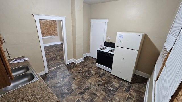 4107 N Campbell St, Detroit, MI 48210 - kitchen with a sink, baseboards, stone finish floor, and white appliances