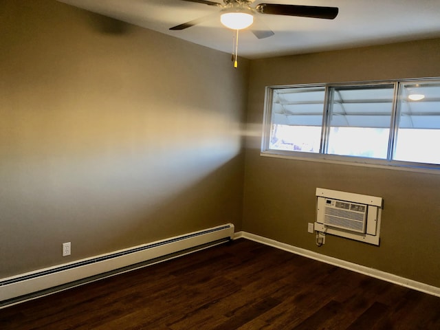 unfurnished room with baseboard heating, an AC wall unit, baseboards, and dark wood-style floors