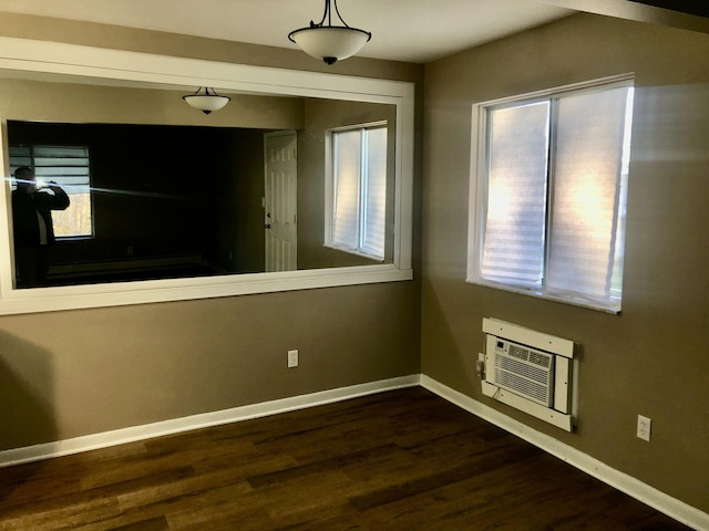 unfurnished room with baseboards, heating unit, and wood finished floors