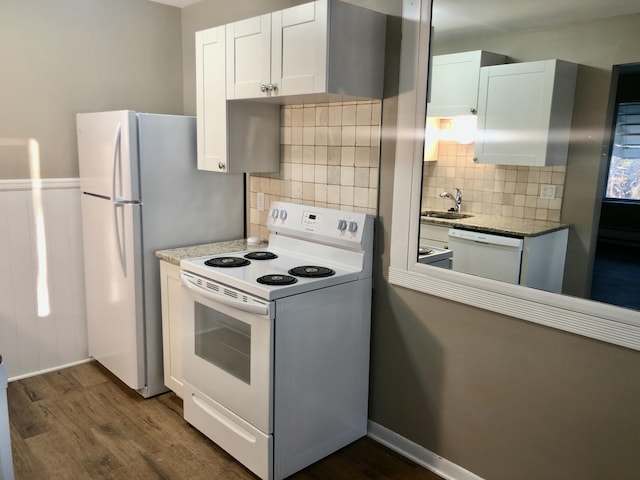kitchen with white appliances, white cabinetry, dark wood-style flooring, a sink, and backsplash