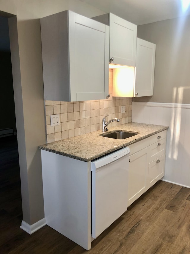 kitchen with a sink, dark wood-type flooring, dishwasher, and light stone countertops