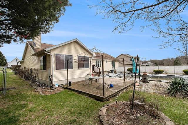 back of house featuring a yard, a fenced backyard, a deck, and a chimney