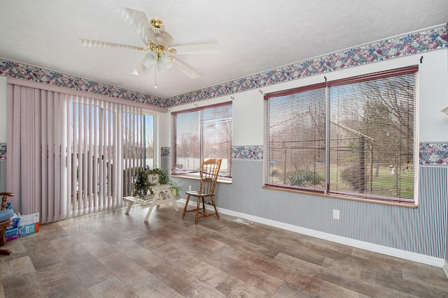 sitting room featuring a textured ceiling, wood finished floors, baseboards, and a ceiling fan