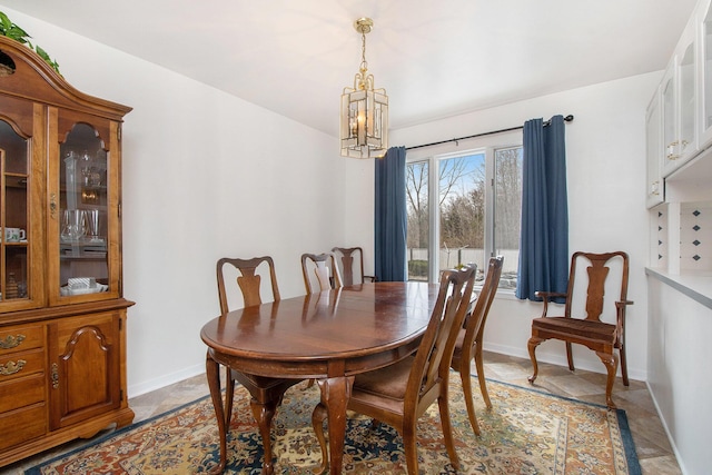 dining space with baseboards and a chandelier