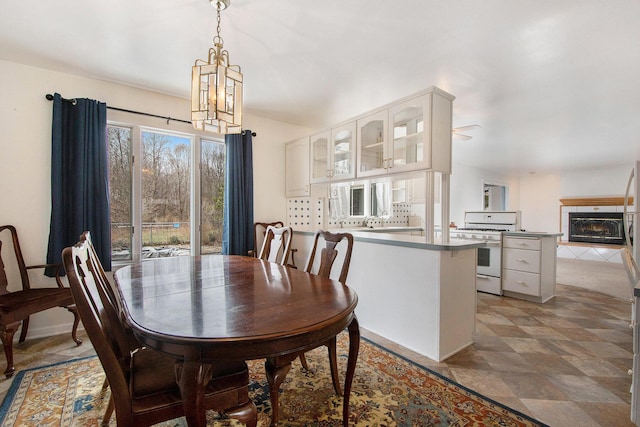 dining room featuring an inviting chandelier and a tiled fireplace