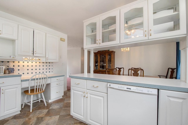kitchen featuring glass insert cabinets, white cabinets, stone finish flooring, light countertops, and white dishwasher