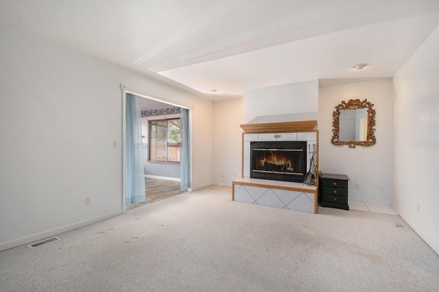 unfurnished living room with visible vents, baseboards, carpet flooring, and a fireplace