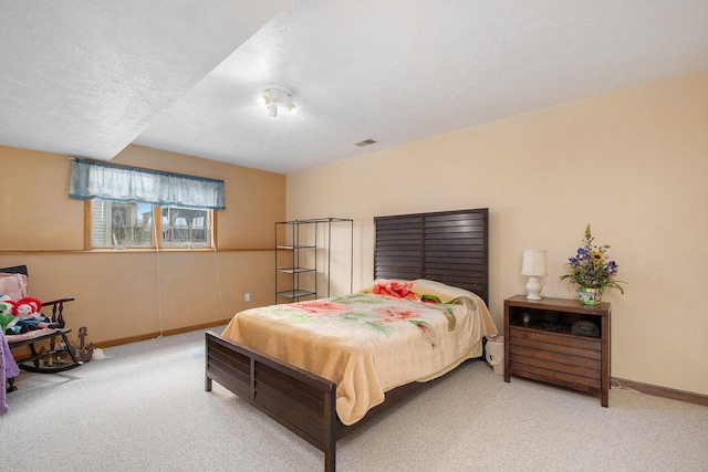 carpeted bedroom with a textured ceiling, baseboards, and visible vents