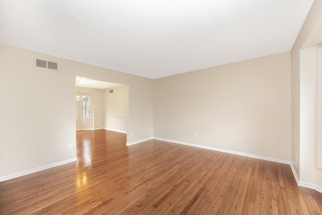 5521 Lohr Lake Dr, Ann Arbor, MI 48108 - unfurnished room with a chandelier, light wood-style flooring, and baseboards