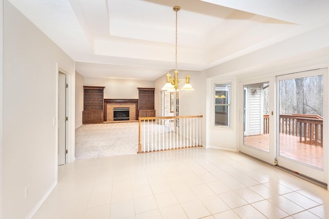 5521 Lohr Lake Dr, Ann Arbor, MI 48108 - unfurnished living room featuring a raised ceiling, baseboards, a fireplace, and a chandelier