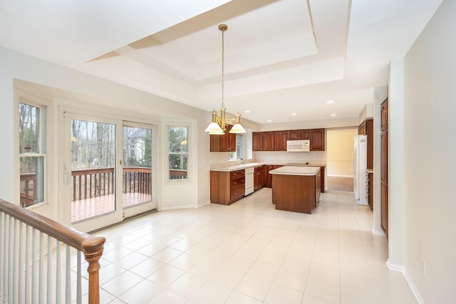 5521 Lohr Lake Dr, Ann Arbor, MI 48108 - kitchen with white appliances, light countertops, a tray ceiling, a center island, and baseboards
