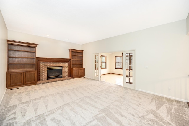 5521 Lohr Lake Dr, Ann Arbor, MI 48108 - unfurnished living room with baseboards, carpet floors, a brick fireplace, and french doors