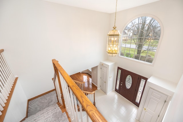 5521 Lohr Lake Dr, Ann Arbor, MI 48108 - foyer entrance featuring baseboards, a chandelier, a high ceiling, and stairs
