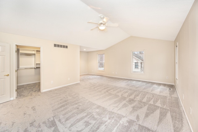5521 Lohr Lake Dr, Ann Arbor, MI 48108 - unfurnished bedroom with carpet flooring, lofted ceiling, baseboards, a ceiling fan, and a walk in closet