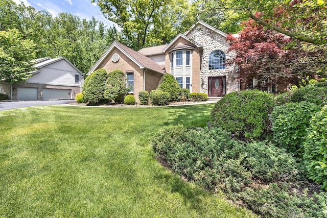 5521 Lohr Lake Dr, Ann Arbor, MI 48108 - traditional home featuring stone siding, a front yard, a garage, and brick siding