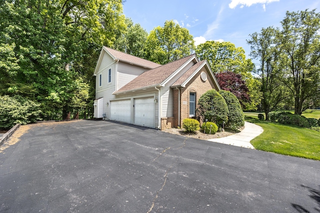 5521 Lohr Lake Dr, Ann Arbor, MI 48108 - view of side of home featuring a garage, brick siding, driveway, a shingled roof, and a lawn