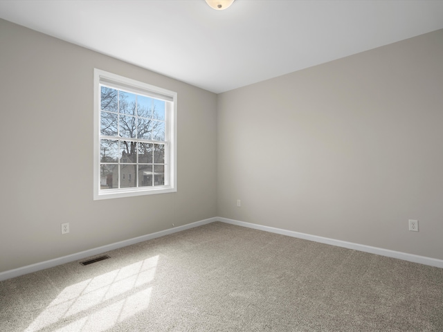 carpeted empty room featuring baseboards and visible vents