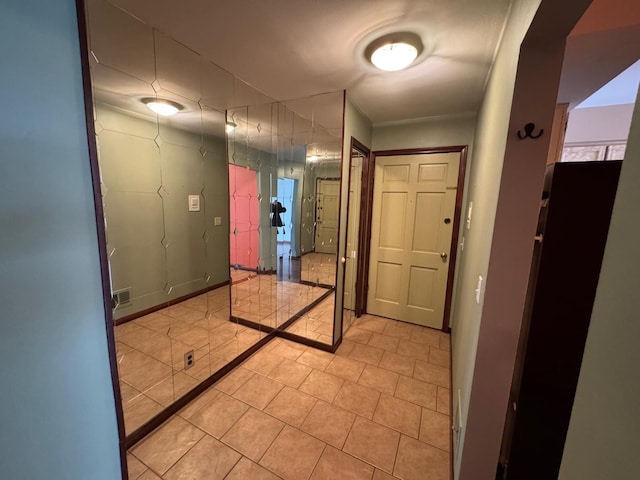 hall featuring visible vents and light tile patterned floors