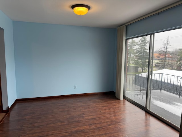 empty room featuring baseboards and dark wood-style floors