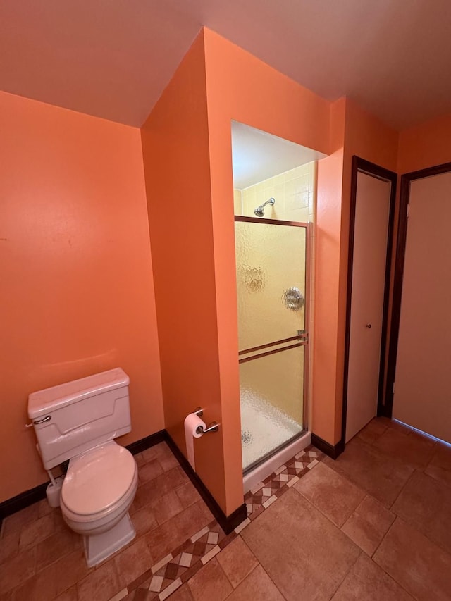 full bathroom featuring baseboards, a shower stall, and toilet