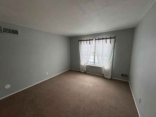 carpeted spare room with baseboards and visible vents
