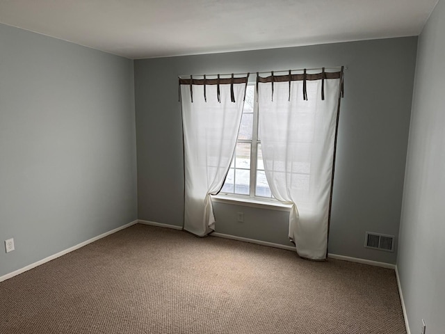 carpeted spare room with baseboards and visible vents