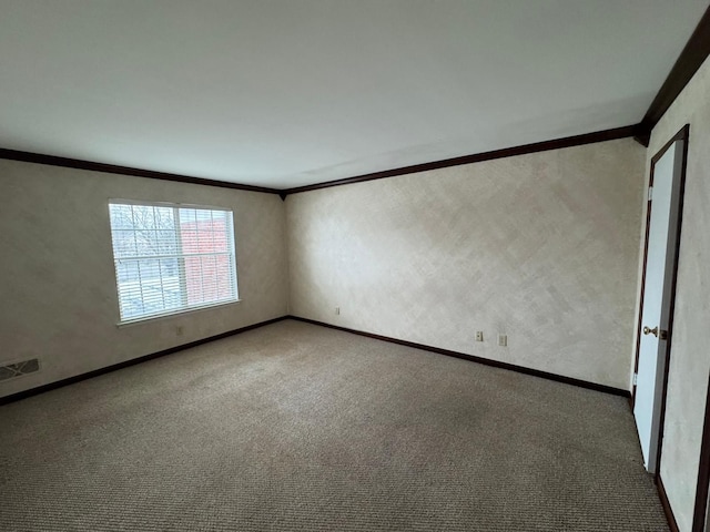 unfurnished room with carpet flooring, baseboards, visible vents, and ornamental molding