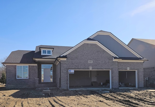 back of property with a garage and brick siding