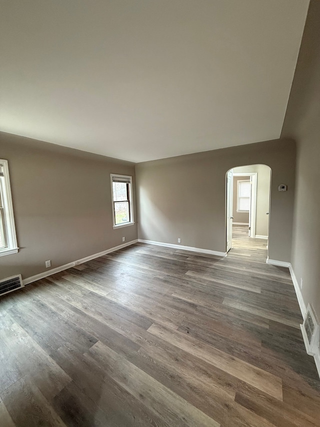 18655 Strasburg St, Detroit, MI 48205 - empty room with arched walkways, dark wood-type flooring, and visible vents