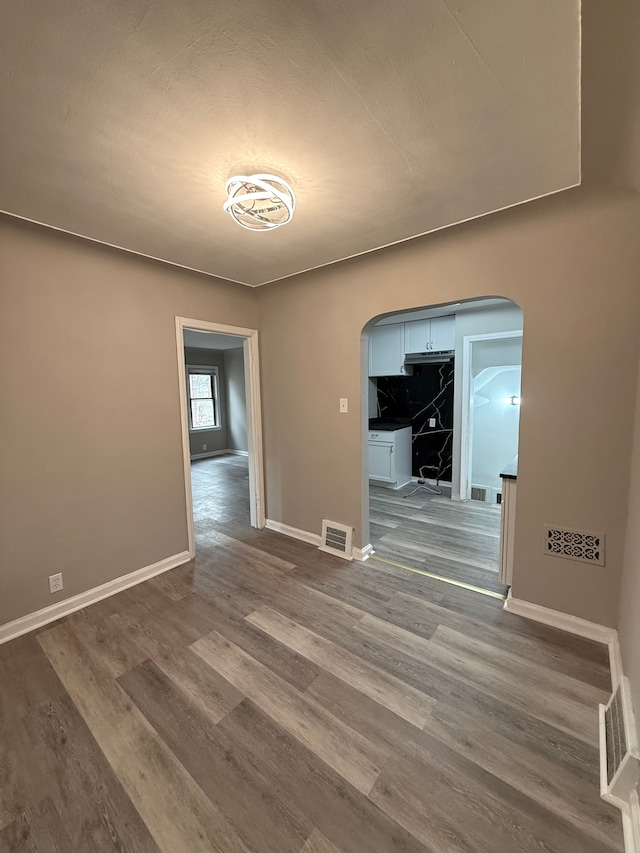 18655 Strasburg St, Detroit, MI 48205 - unfurnished room with visible vents, baseboards, arched walkways, and wood finished floors