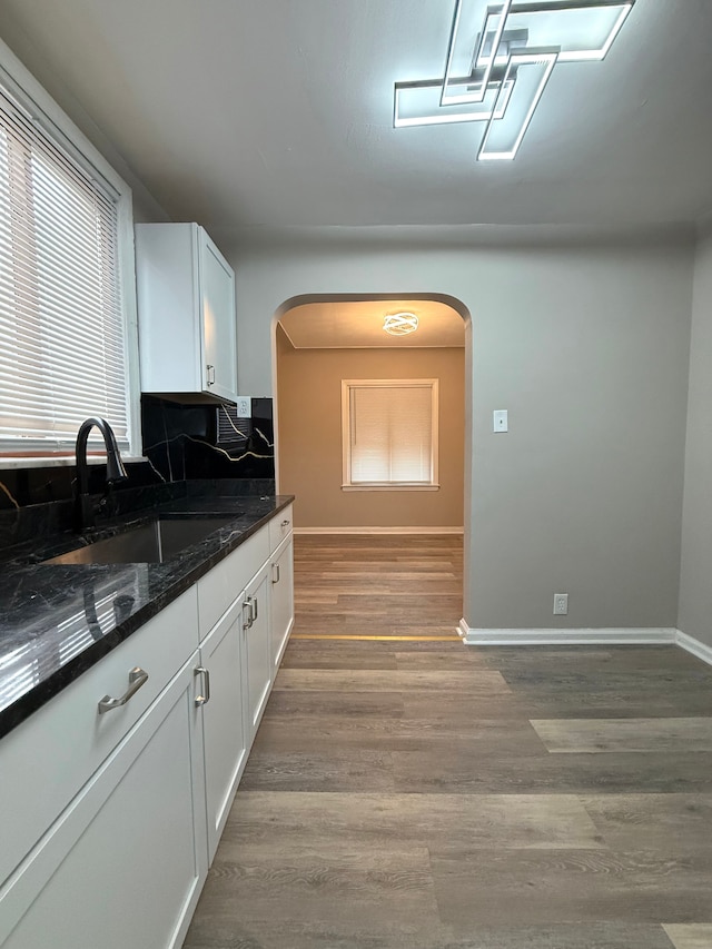18655 Strasburg St, Detroit, MI 48205 - kitchen with arched walkways, wood finished floors, a sink, and white cabinets