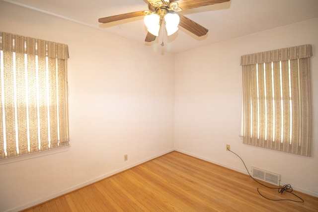 empty room with visible vents, baseboards, and wood finished floors