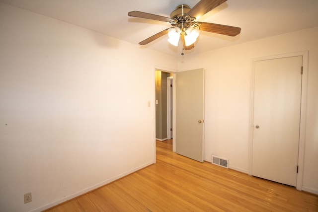unfurnished bedroom with visible vents, baseboards, a ceiling fan, and light wood-style floors