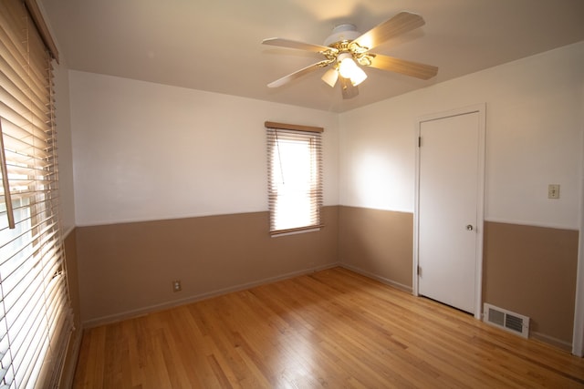 unfurnished room with light wood-style flooring, ceiling fan, and visible vents