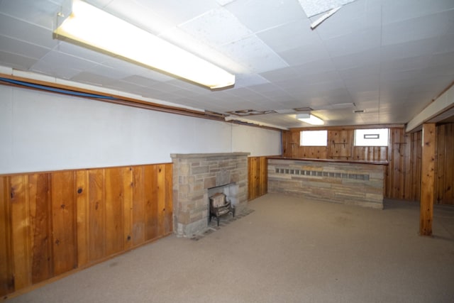 basement featuring wood walls, carpet, and wainscoting