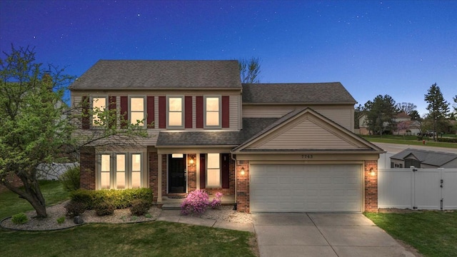 view of front of home with brick siding, a front lawn, concrete driveway, and an attached garage