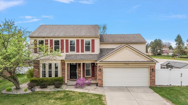 view of front of home featuring a front yard, brick siding, concrete driveway, an attached garage, and fence