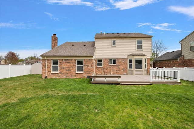 back of house with a chimney, a yard, a wooden deck, and a fenced backyard